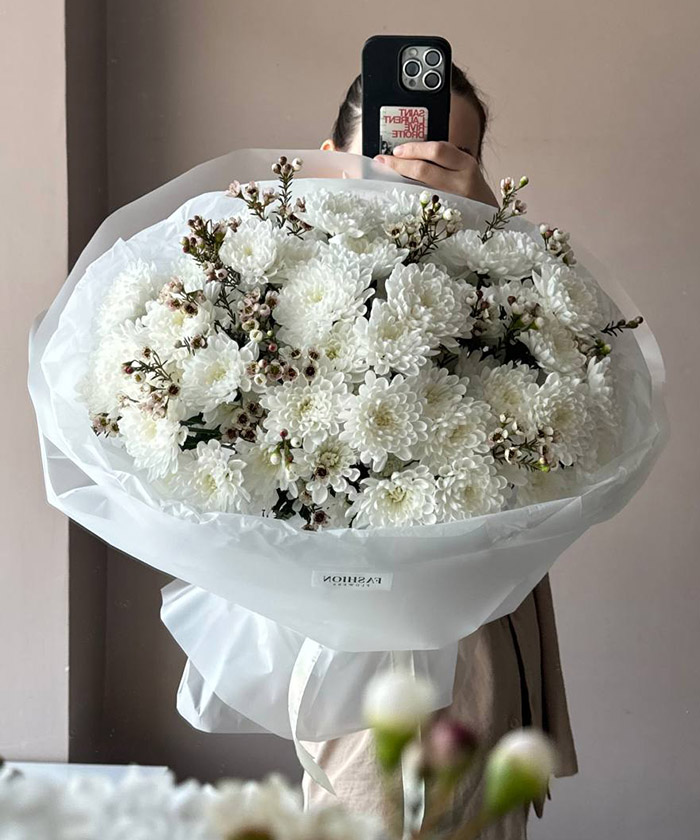 11 белых хризантем и хамелациум в букете 