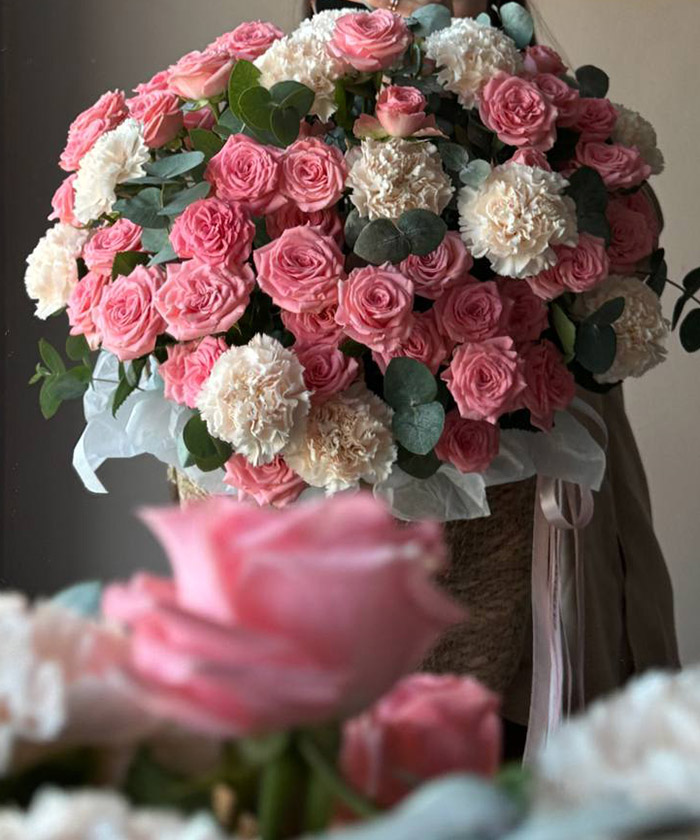 Розовые розы и диантусы в плетёной корзине 